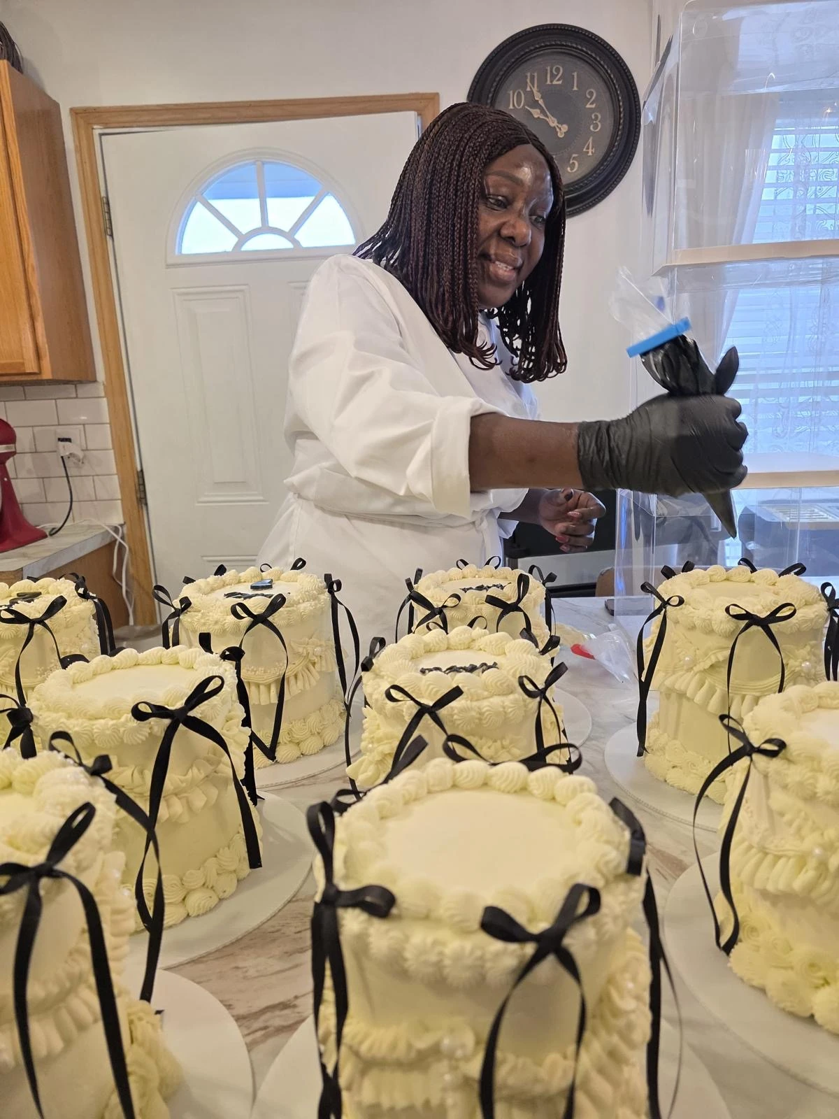Debby decorating ivory cakes with black bows