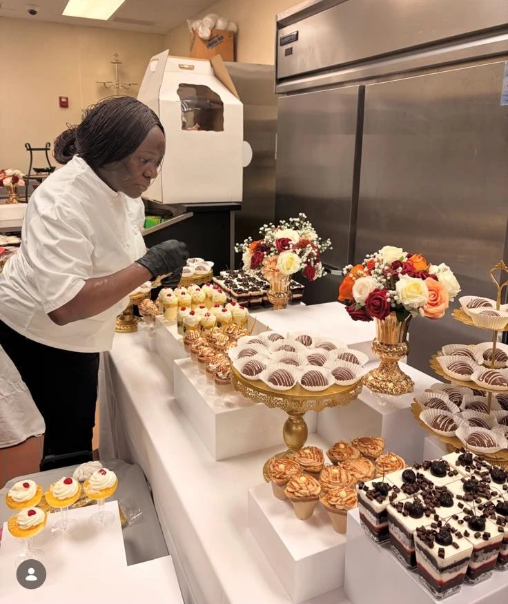 Debby in her white chef jacket finishing a dessert table