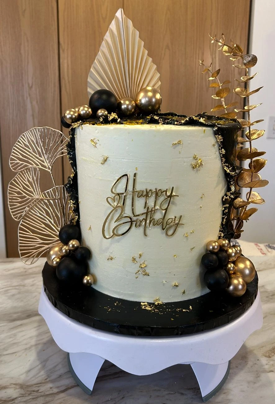 Ivory celebration cake with black and gold details