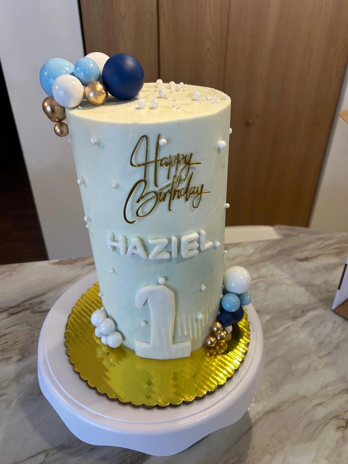 Pale-blue first-birthday cake with gold details