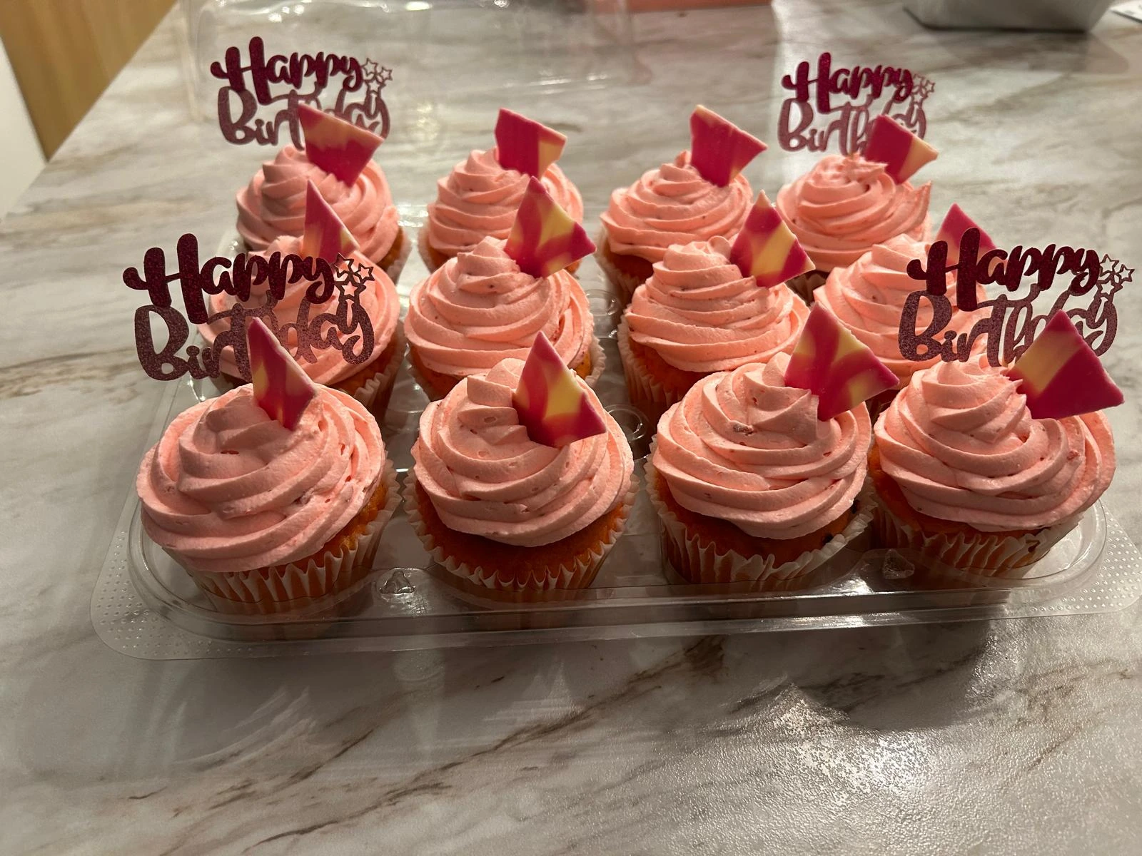 Pink birthday cupcakes with decorative toppers