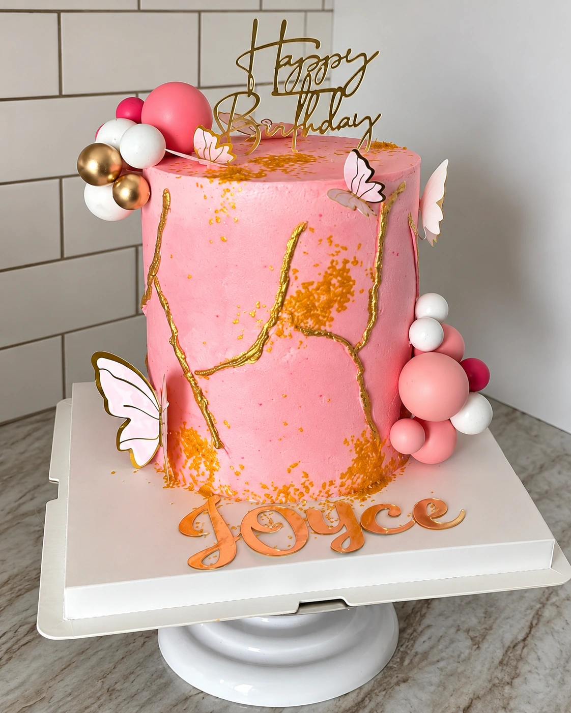 Pink and gold celebration cake with floral decoration