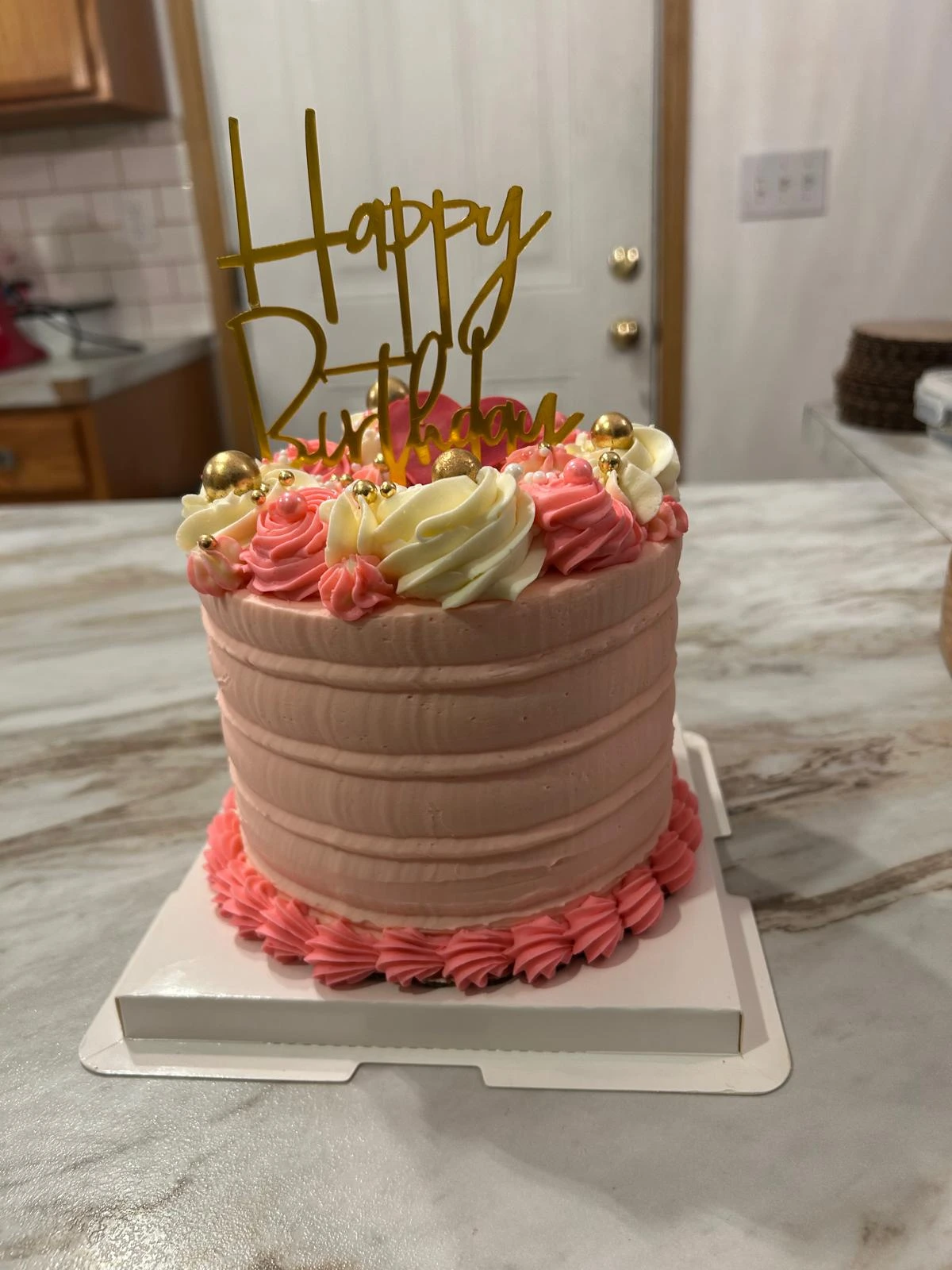 Pink rosette birthday cake with a gold topper